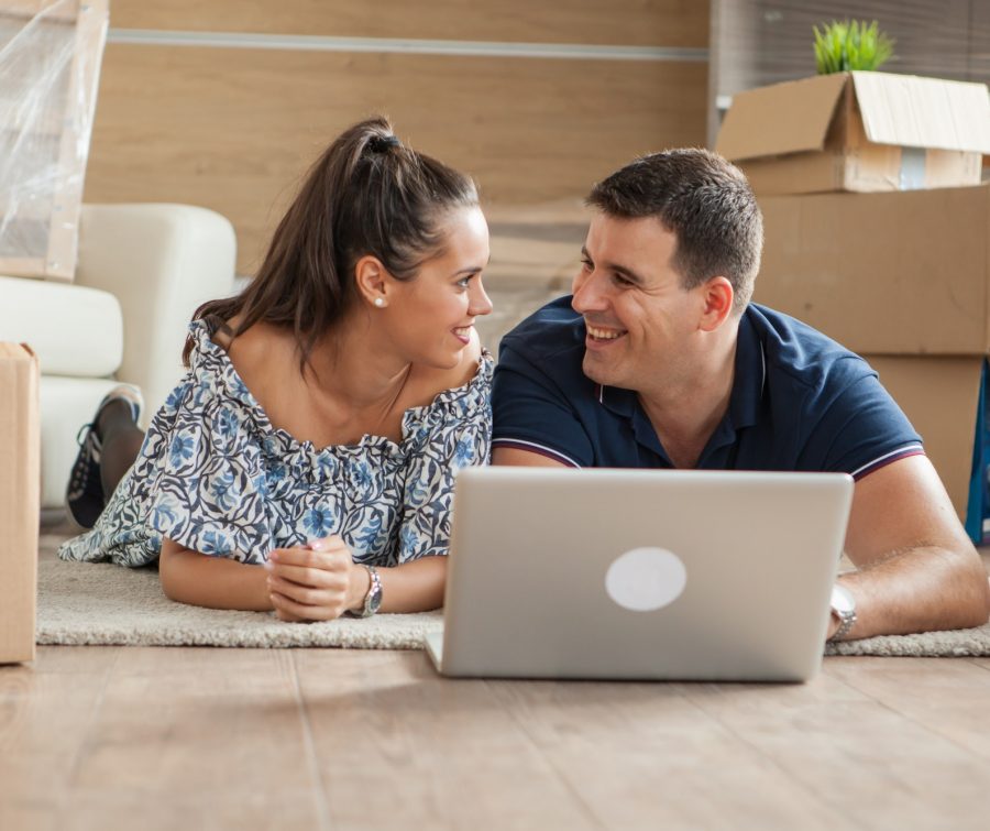 Young adults using their laptop in the new flat